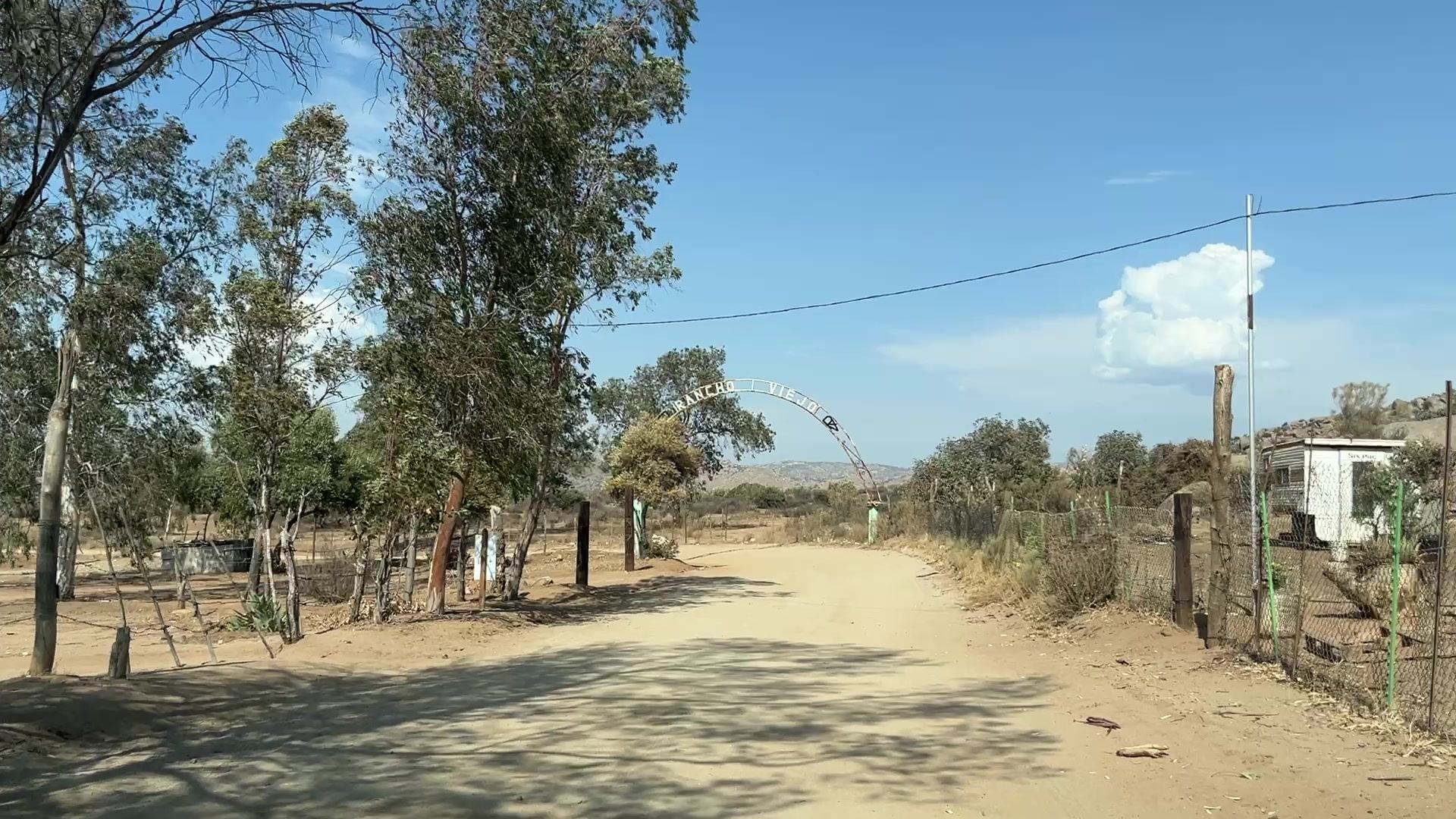Arco de entrada con la leyenda Rancho Viejo sobre el camino de acceso